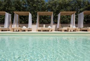 a group of tables and chairs next to the water at Residenza Il Sole in Monopoli
