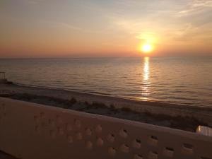 スカラ・フォルカスにあるGolden sunset beach houseのバルコニーから海に沈む夕日