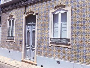 a building with a blue and yellow tiles on it at Terrace Barqueta Studio in Faro