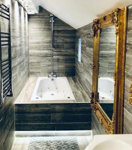 黑潭的住宿－Luxury Apartment，带浴缸和镜子的浴室