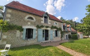 uma antiga casa de pedra com portas azuis e um quintal em LA PINÇONNIERE em Verneuil-sur-Indre