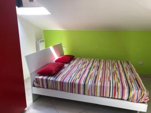 - un lit avec 2 oreillers rouges dans une pièce verte dans l'établissement Appartamento vacanze Fondi, à Fondi