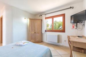 a bedroom with a bed and a desk and a television at Hotel Bonsai in San Teodoro