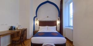 sypialnia z niebiesko-białym łóżkiem i oknem w obiekcie Dada w Trieście