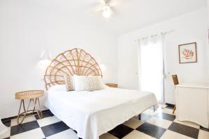 a white bedroom with a large bed and a checkered floor at Urbanización El Oasis, 20 Villas en 1ª Línea Playa in Denia
