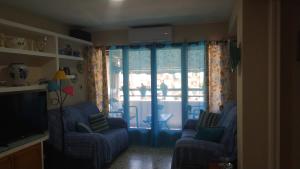 a living room with two chairs and a television at Apartamento Marín El Campello in El Campello