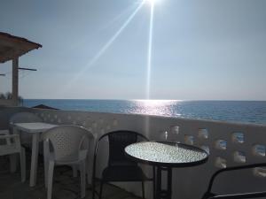 une terrasse avec des tables et des chaises et l'océan dans l'établissement Golden sunset beach house, à Skála Foúrkas