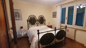 a bedroom with a bed with a wrought iron headboard at Villa Sargiano in Arezzo