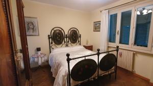 una camera con letto e testiera in ferro battuto di Villa Sargiano ad Arezzo