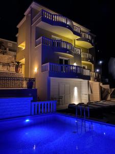 a villa with a swimming pool at night at Apartments - Villa Sabrina in Brela