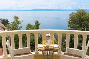 una mesa en un balcón con vistas al agua en Apartments - Villa Sabrina, en Brela