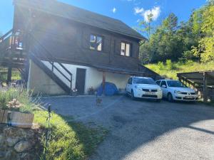 a house with two cars parked in front of it at soleil et vue in Barcelonnette