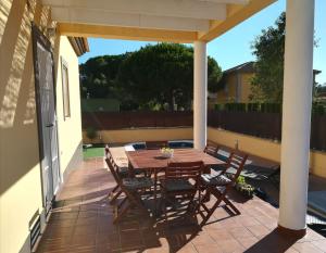 einen Holztisch und Stühle auf einer Terrasse in der Unterkunft Isla Verde y Mar in Isla Cristina