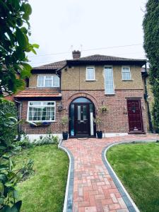 a brick house with a brick driveway at The Film Studio Appartement 5 min to Harry Potter in Leavesden Green