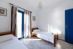 Cette chambre comprend 2 lits et une fenêtre. dans l'établissement Golden sunset beach house, à Skála Foúrkas