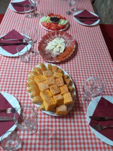 stół z talerzami żywności na czerwono-białej tkaninie stołowej w obiekcie Apartment Mond w mieście Virpazar