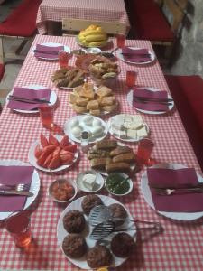 een tafel met borden met voedsel op een rode en witte tafeldoek bij Apartment Mond in Virpazar