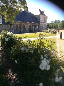 オンフルールにあるla maison du phare DE HONFLEUR chambre d hôtes B&B -jacuzzi privé- shabby chicの白い花が目の前に広い建物