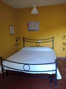 a bedroom with a large bed in a yellow wall at Appartamento il Giglio in Montale