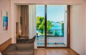 ein Wohnzimmer mit einem großen Fenster mit Blick auf das Wasser in der Unterkunft Hotel Eden in Podstrana