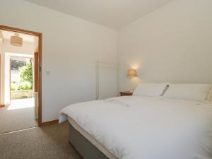 a white bedroom with a large bed and a window at Pond in Shaftesbury