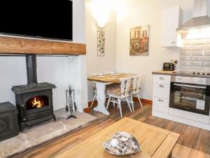 a kitchen with a stove and a dining room with a table at Mill Cottage in Belford