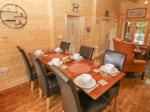 Bryn Derwen Lodge في بانغور: غرفة طعام مع طاولة وكراسي خشبية