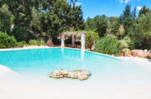 a swimming pool with a waterfall in a backyard at Puntebianche B&B in Ceglie Messapica
