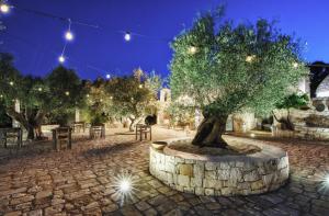 Ein Baum in einem Steinkreis mit Lichtern in der Unterkunft Puntebianche B&B in Ceglie Messapica