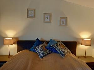 een slaapkamer met een bed met kussens en 2 lampen bij Bij de Vlaamse Schuur in Wagenberg