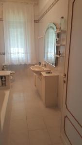 a white bathroom with a sink and a mirror at Villa Elena in Portovenere