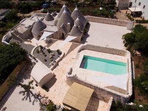 
a large swimming pool with a large building behind it at TRULLI TESORO in Cisternino
