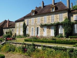 una casa antigua con un jardín delante de ella en Gentilhommière de Lurcy le Bourg, en Lurcy-le-Bourg