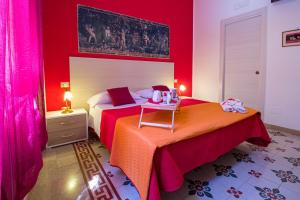 een slaapkamer met 2 bedden en rode muren bij V&V Suite & Breakfast in Pompei