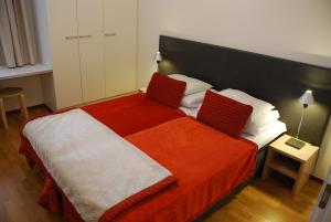 1 dormitorio con 1 cama con manta roja y blanca en Ylläs Chalet 8208, en Ylläs