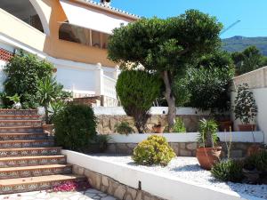 a house with stairs and trees and plants at Villa Denia in Denia