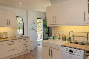 a kitchen with white cabinets and a sink at Sintra • Banzão House with Swimming Pool in Nafarros