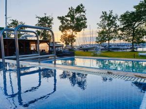 a large swimming pool with a marina in the background at Butique Apartman in Balatonlelle