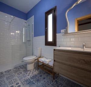 y baño con aseo, lavabo y ducha. en Casa Rural Villa San Juan en Cúllar-Vega
