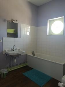 een badkamer met een wastafel en een bad bij La tour du Roy in Villeneuve-sur-Allier