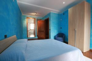 una camera da letto con pareti blu e un grande letto di B&B Linu Ruiu a Santu Lussurgiu