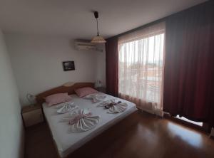 Un pat sau paturi într-o cameră la Family Hotel Denica