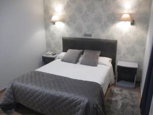 a bedroom with a large bed and two night stands at Hotel Las Moradas in Ávila