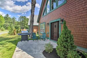 a house with two chairs and a grill in the yard at Condo with Grill Walk to North Conway and Cranmore! in North Conway