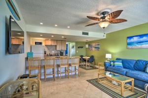 sala de estar con sofá azul y cocina en Sunny Seaside Condo with Pool and Walk to Beach!, en St Pete Beach