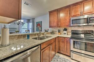 a kitchen with wooden cabinets and stainless steel appliances at Cozy Woodlands Townhome with Deck Near Market Street in The Woodlands