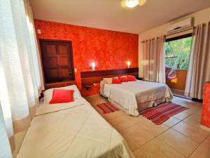 弗洛里亚诺波利斯Pousada Ilha dos Anjos的一间带两张床和红色墙壁的卧室