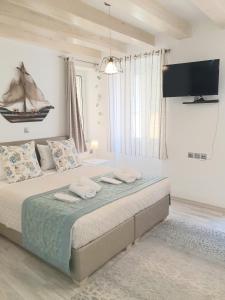 um quarto com uma cama grande e uma televisão na parede em Helens Apartment em Corfu Town