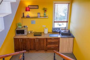 a yellow kitchen with a sink and a microwave at Morski Diament in Władysławowo