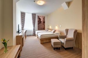 Pokój hotelowy z łóżkiem i krzesłem w obiekcie Hotel GTC 3* superior w mieście Bílovec